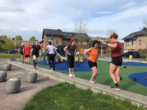 Een training met 7 mensen op een veldje in een woonwijk